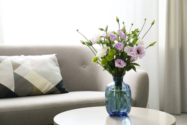 Bouquet of beautiful Eustoma flowers on table in room. Space for text - Zdjęcie, obraz