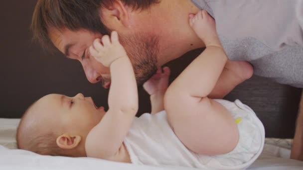 Boldog család. A szakállas apa és az újszülött kislány ölelése. Apaság Szülői boldogság. Szerető apa élvezi, ha kisgyerekkel játszhat. egészséges gyermekgondozás, szerelem. - Felvétel, videó