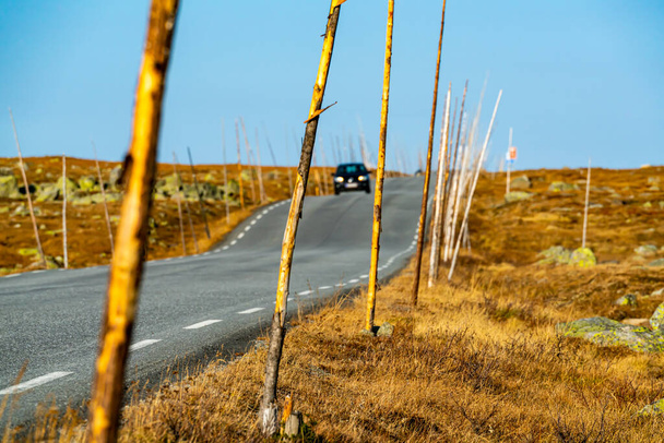 Camino de asfalto a través de las tierras altas de la montaña con un coche borroso que conduce en el fondo. borrosa. .. Foto de alta calidad - Foto, imagen