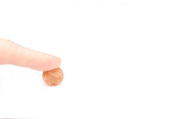Mans finger press one modern cent of USA on the edge isolated on the white background - Fotoğraf, Görsel