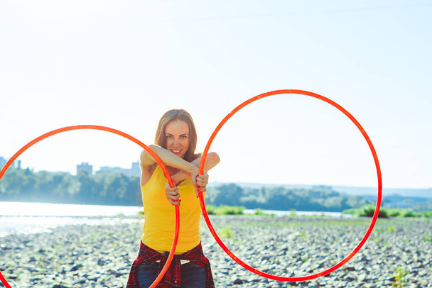 mujer gira hula hoop en el fondo de la naturaleza - Foto, imagen