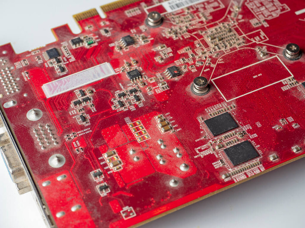 staubige Leiterplatte mit roten Chips. Alte Grafikkarte - Foto, Bild
