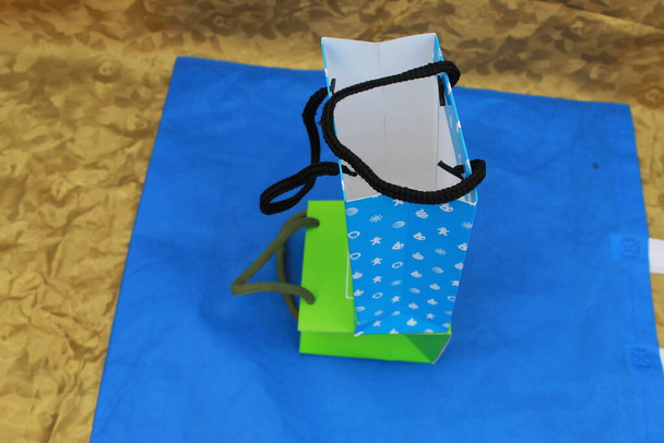 ECO Friendly Shopping Bags mit schönem Hintergrund. Vliesbeutel. Papiertaschen mit Schlaufengriff auf blauem Hintergrund - Foto, Bild