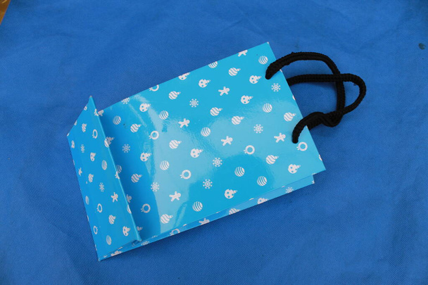 エコフレンドリーなショッピングバッグで美しい背景。不織布バッグ。紙バッグ付きループハンドル上ブルー背景 - 写真・画像