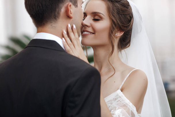 Wedding portrait of a smiling bride and groom kissing - Photo, Image