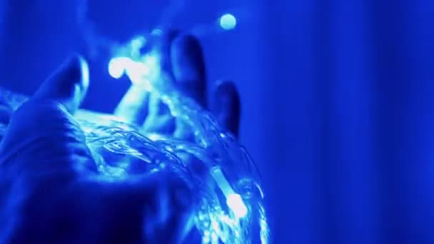 Weibliche Hand hält Weihnachtsgirlanden in weicher Defokussierung. 4K. - Filmmaterial, Video