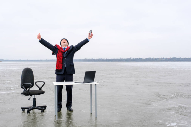 hombre de negocios en traje se para con las manos extendidas en una mesa en el lago del medio - Foto, Imagen