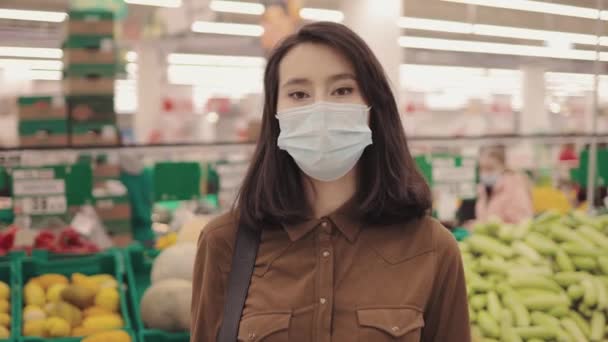 Young woman standing in protective mask in grocery market store - Video