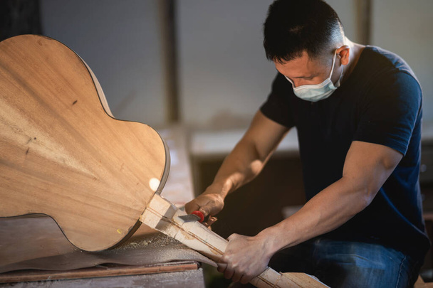 artesano que hace la guitarra en la mesa de madera, captador concepto de trabajo - Foto, Imagen