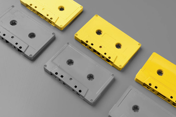 Yellow and gray audio cassettes on gray background top view - Photo, Image