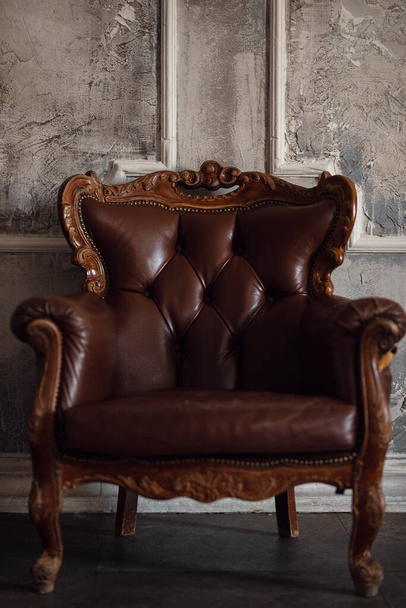 brown soft armchair against vintage gray wall background - Foto, Imagem