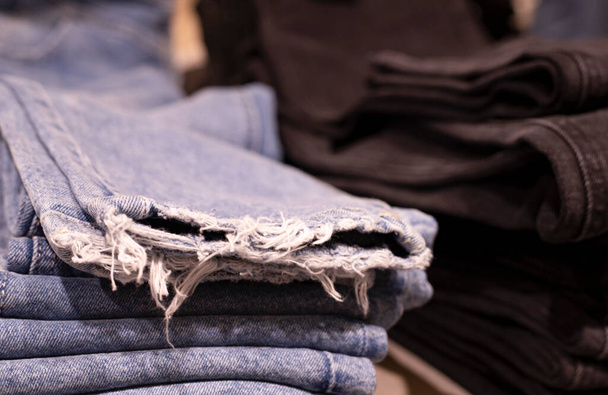 Kadın giysileri - sonbahar kış koleksiyonu. Kot pantolon mağazada. Bilinçli tüketim ve geri dönüşüm kavramı. - Fotoğraf, Görsel
