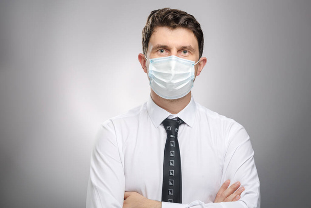 Mann mit Mundschutz, Büroangestellte im weißen Hemd mit Maske zum Schutz vor Covid-19.  - Foto, Bild