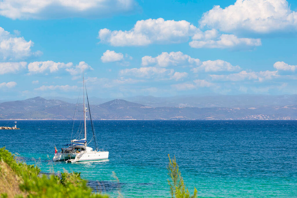 Sail boat, yacht in a beautiful bay with blue water during sunny day, Chalkidiki, Greece - Valokuva, kuva