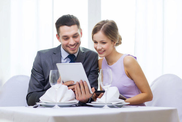 Couple with menus on tablet pc at restaurant - Foto, Imagen