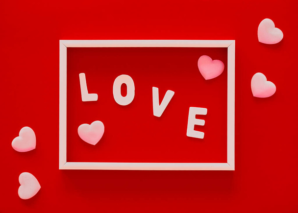 Día de San Valentín fondo rojo con marco blanco, palabra Amor y corazones rosados. Día de la Madre, 8 de marzo tarjeta de felicitación - Foto, imagen