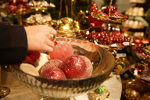 Karácsonyi vásárlás, kézfogás rózsaszín csecsebecse. Vásárolni csodálatos luxus baubles áruház Zürich Svájc. - Fotó, kép