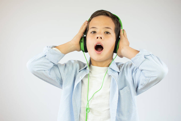 Ευτυχισμένος έφηβος όμορφο αγόρι με ακουστικά, απομονώνονται σε λευκό φόντο - Φωτογραφία, εικόνα