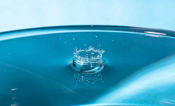 Abstract een uitbraak van water. Een plons water van dichtbij. Bevroren waterdruppel gefotografeerd op hoge snelheid.Langzaam druppelen van vloeistof met luchtbellen. Natuur achtergronden of behangsel.Bevroren vloeibare spatten - Foto, afbeelding