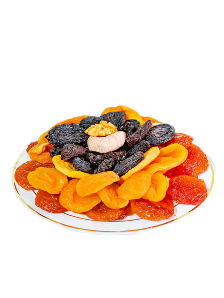 Conjunto de frutos secos en un plato sobre un fondo blanco - Foto, imagen