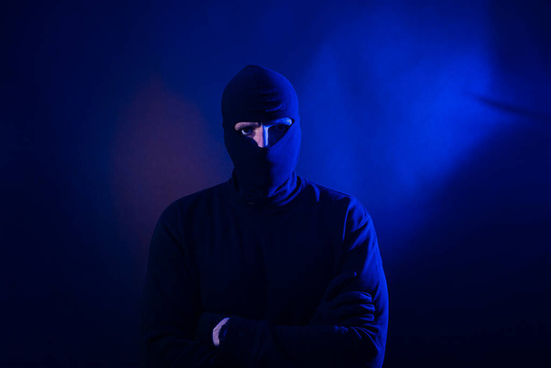 Portrait of Caucasian thief with hood. Includes police lights. Includes police lights. - Foto, imagen
