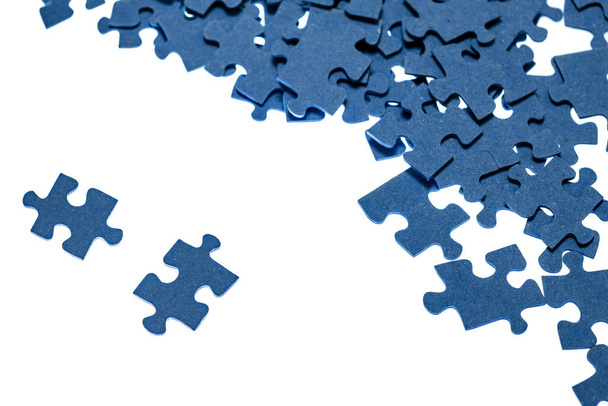 small blue puzzle pieces on a white background, add a picture from small pieces, a useful exercise for the brain, training attention and patience - Фото, изображение