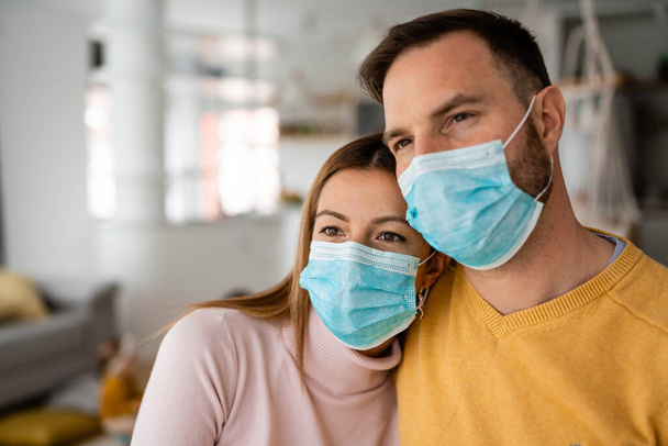 Home isolation during coronavirus quarantine. Man and woman wearing face mask. Coronavirus protection and prevention. Stay home - Foto, afbeelding