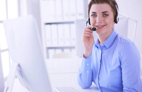 Serious pretty young woman working as support phone operator with headset in office - Photo, Image