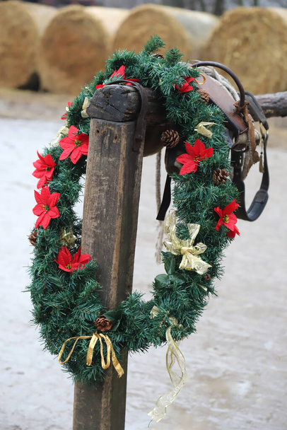 Krásné ručně vyrobené vánoční věnce věnec dekorace visí na dřevěné koně dok na venkově zvířat farmy - Fotografie, Obrázek