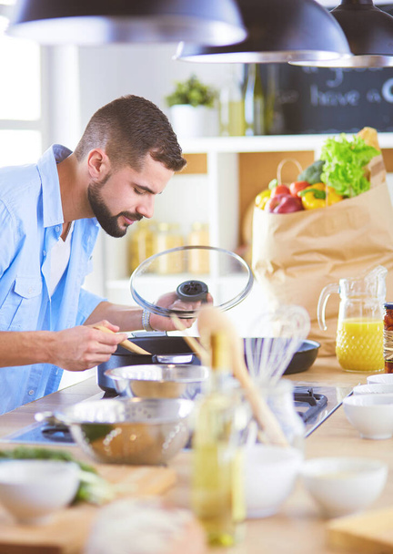 Homem seguindo receita em tablet digital e cozinhar comida saborosa e saudável na cozinha em casa - Foto, Imagem