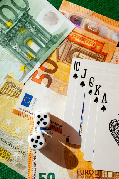 kocka, kártyázás egy zöld ruhán egy kaszinó dollárban és eurobankjegyekben - Fotó, kép