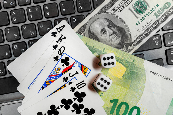 dice, playing cards on laptop keyboard dollars and euro bills - Photo, Image