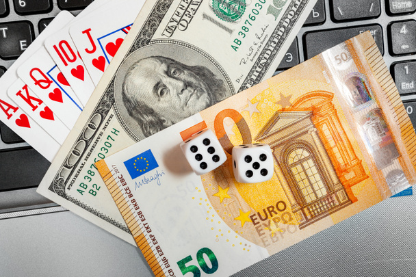 dadi, carte da gioco su tastiera portatile dollari e banconote in euro - Foto, immagini