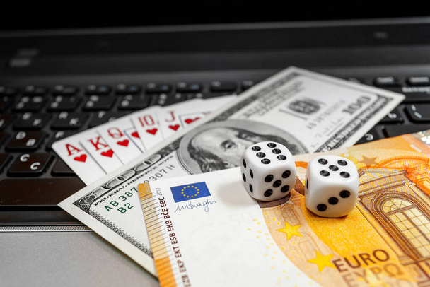 кости, игральные карты на ноутбуке клавиатуры долларов и евро счета - Фото, изображение