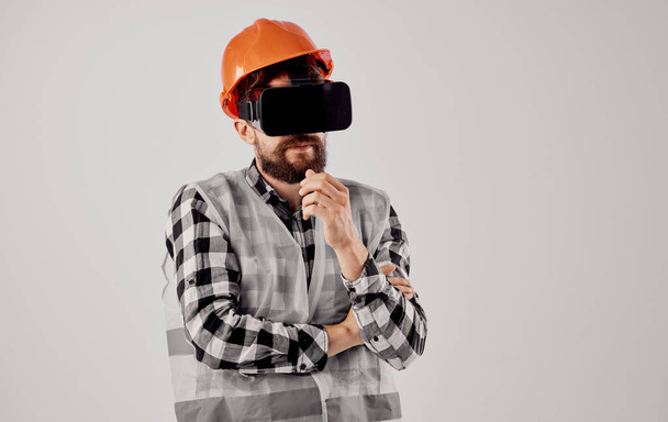 3D仮想現実メガネと頭の上にオレンジのハード帽子を身に着けている土木技術者 - 写真・画像
