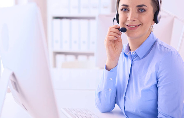 Serious pretty young woman working as support phone operator with headset in office - Фото, зображення