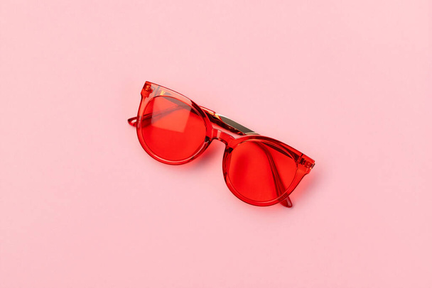 Flat lay top view red fashionable sunglasses on pink background - Photo, Image
