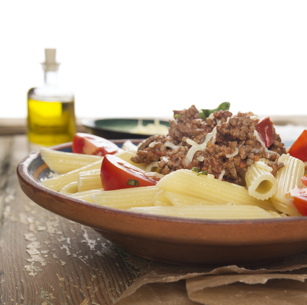 Penne pasta met bolognese saus, geïsoleerd - Foto, afbeelding