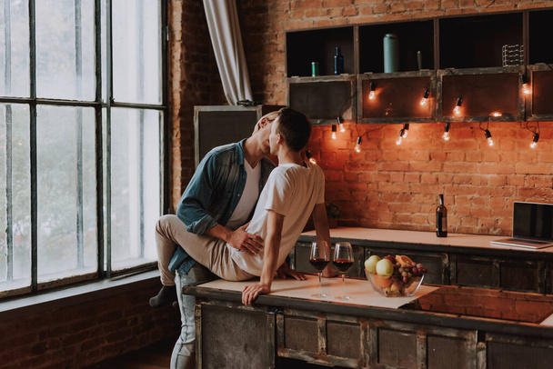 Liebevolles schwules Paar zu Hause. Zwei hübsche leidenschaftliche Männer, die sich in der Küche umarmen und küssen. Homosexualität. - Foto, Bild