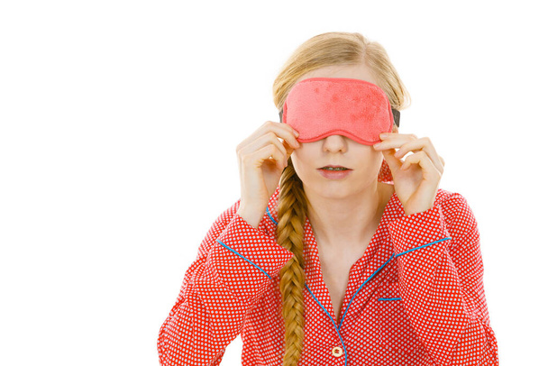 Sleep bedroom accessories concept. Sleepy woman wearing pink eye band and pajamas. - Fotografie, Obrázek