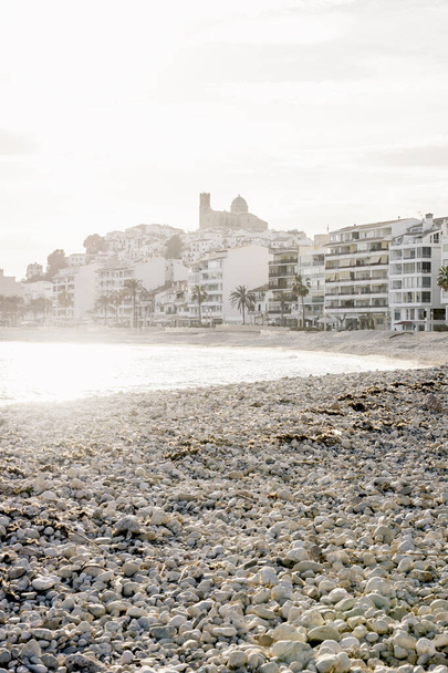 海岸とバックライト、アルテア、コスタ・ブランカ、スペインと旧市街のビューで2020年1月にグロリア嵐の後アルテアで破壊された石のビーチ - 写真・画像