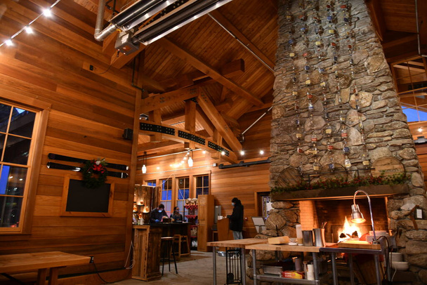 Whistlepig restaurant at Stowe Ski Resort in Vermont, warm light interior with fireplace, hi-resolution image. - Fotoğraf, Görsel