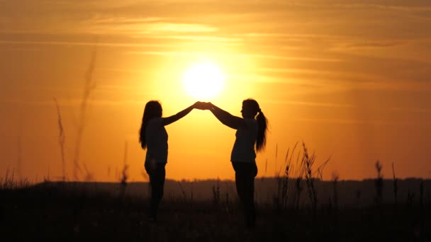 Máma a dcera se dotkly dlaněmi jeden druhého, ruce nad krásným západem slunce. Šťastná rodinná matka a dcera na poli na slunci. koncepce šťastné rodiny dětí a dětství. Maminka a dítě - Záběry, video