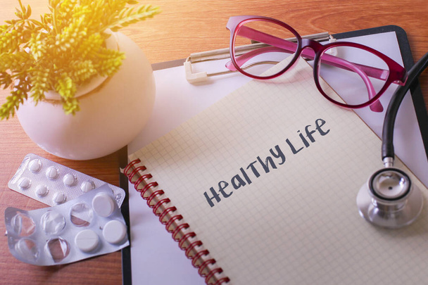 健康的な生活の言葉を医学の概念としてノートブック上の聴診器 - 写真・画像