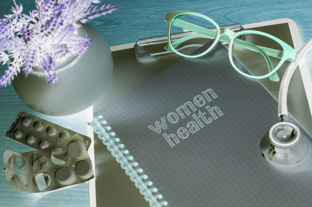 Stethoskop auf Notizbuch mit Women 's Health Wörtern als medizinisches Konzept - Foto, Bild