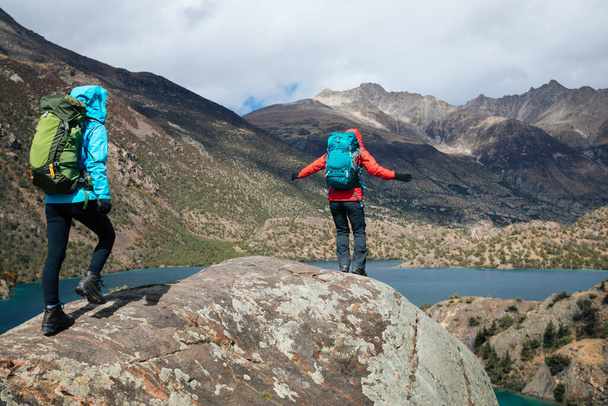 Two women backpackers hiking  in beautiful winter mountains - 写真・画像