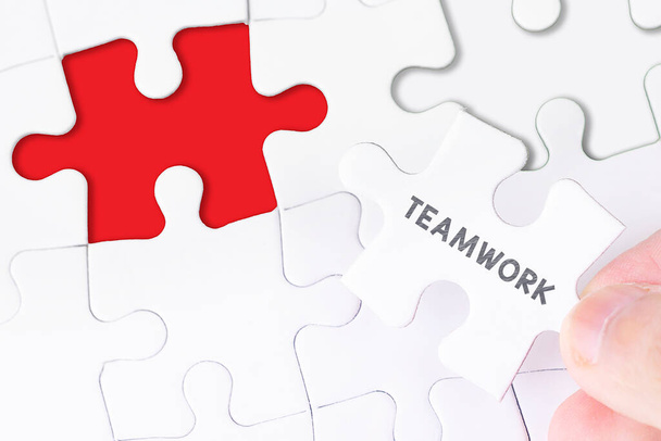 Female hand and missing puzzle with TEAMWORK WORD - Photo, Image