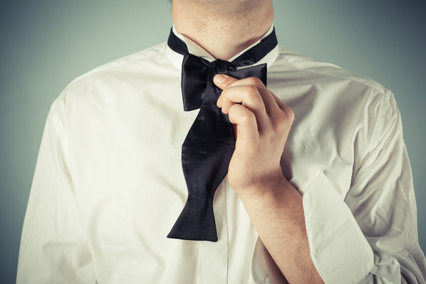 Young man tying a bow tie - Photo, Image