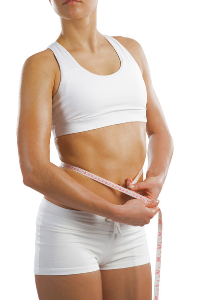 Mujer atlética que mide la cinta métrica de la cintura
 - Foto, Imagen