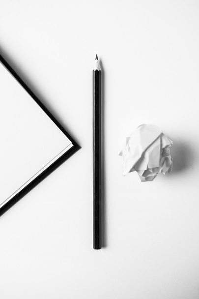 Closeup of book, pencil and crumpled paper on white desk.  - Fotó, kép